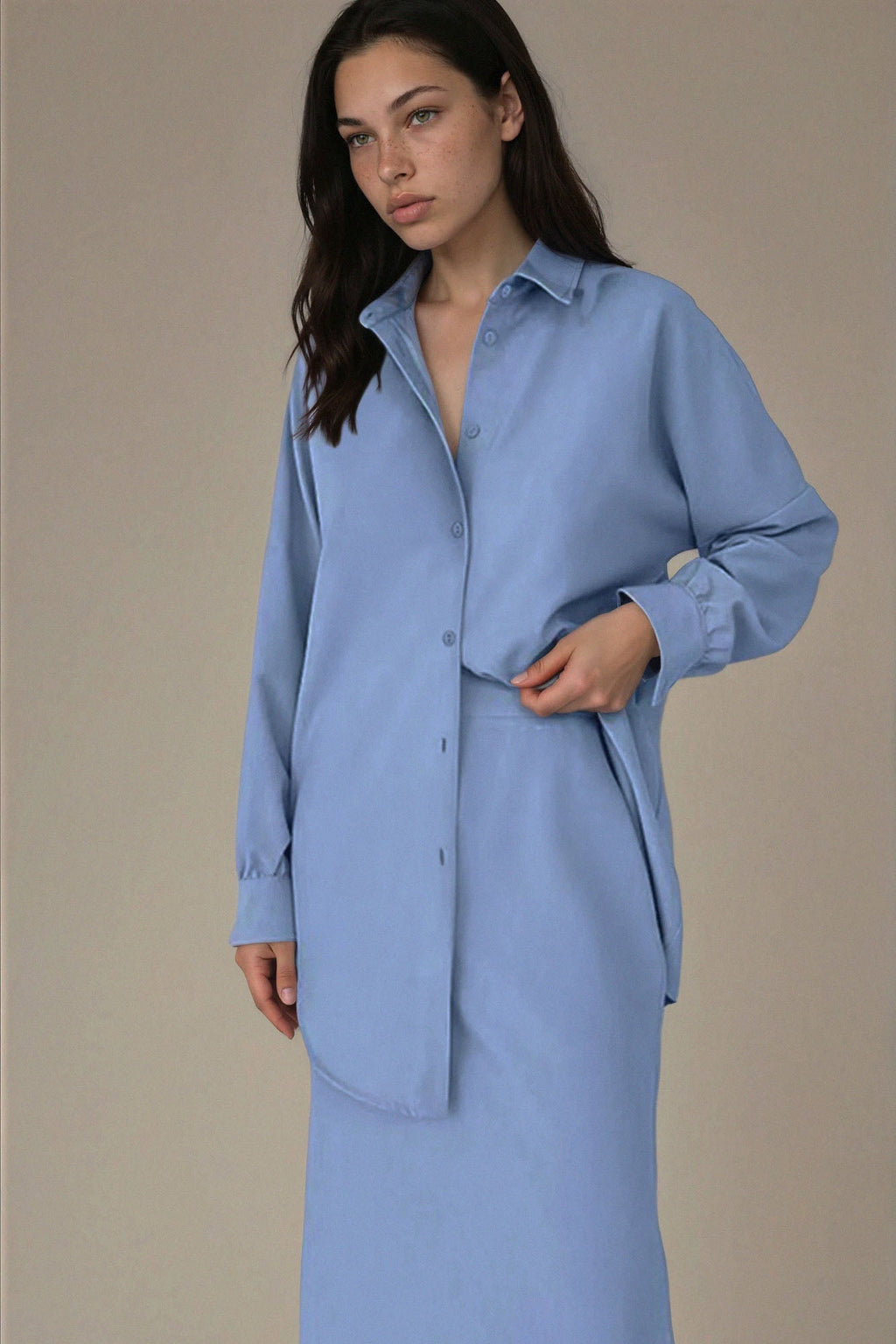 Woman wearing a light blue dress against a beige background
