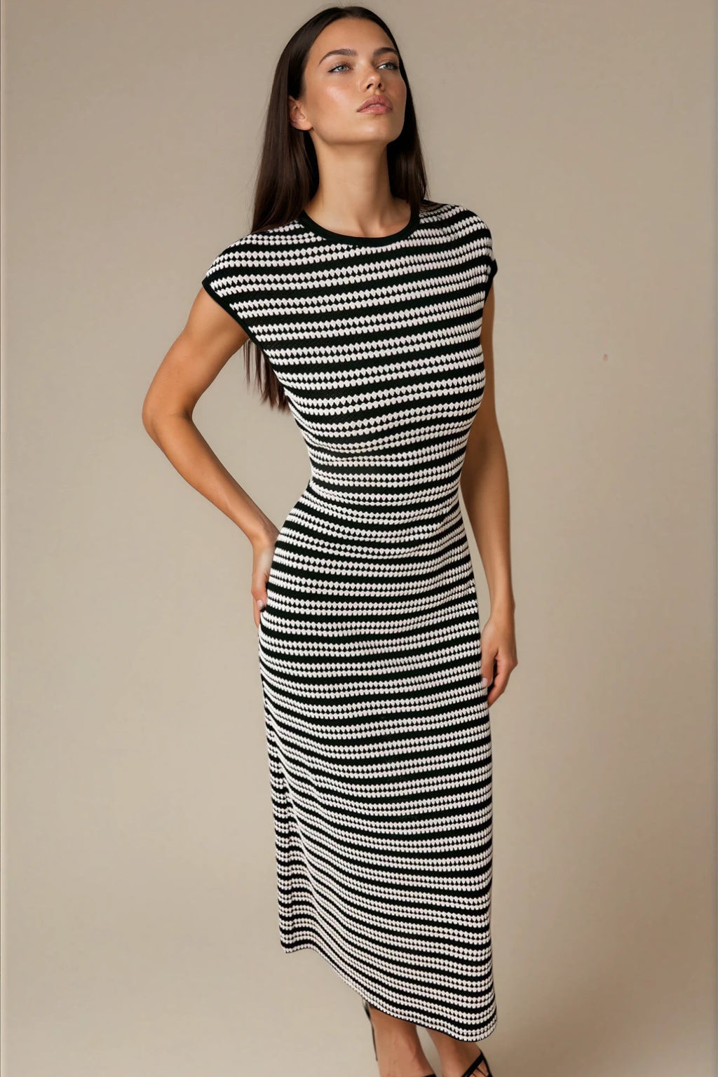 Woman wearing a black and white patterned dress against a beige background