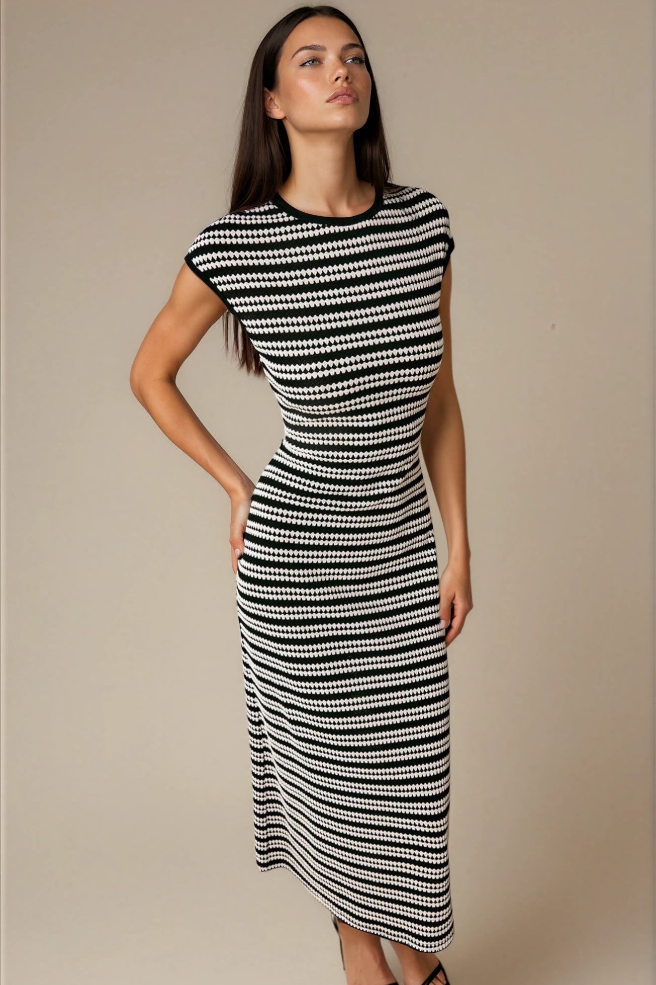 Woman wearing a black and white patterned dress against a beige background