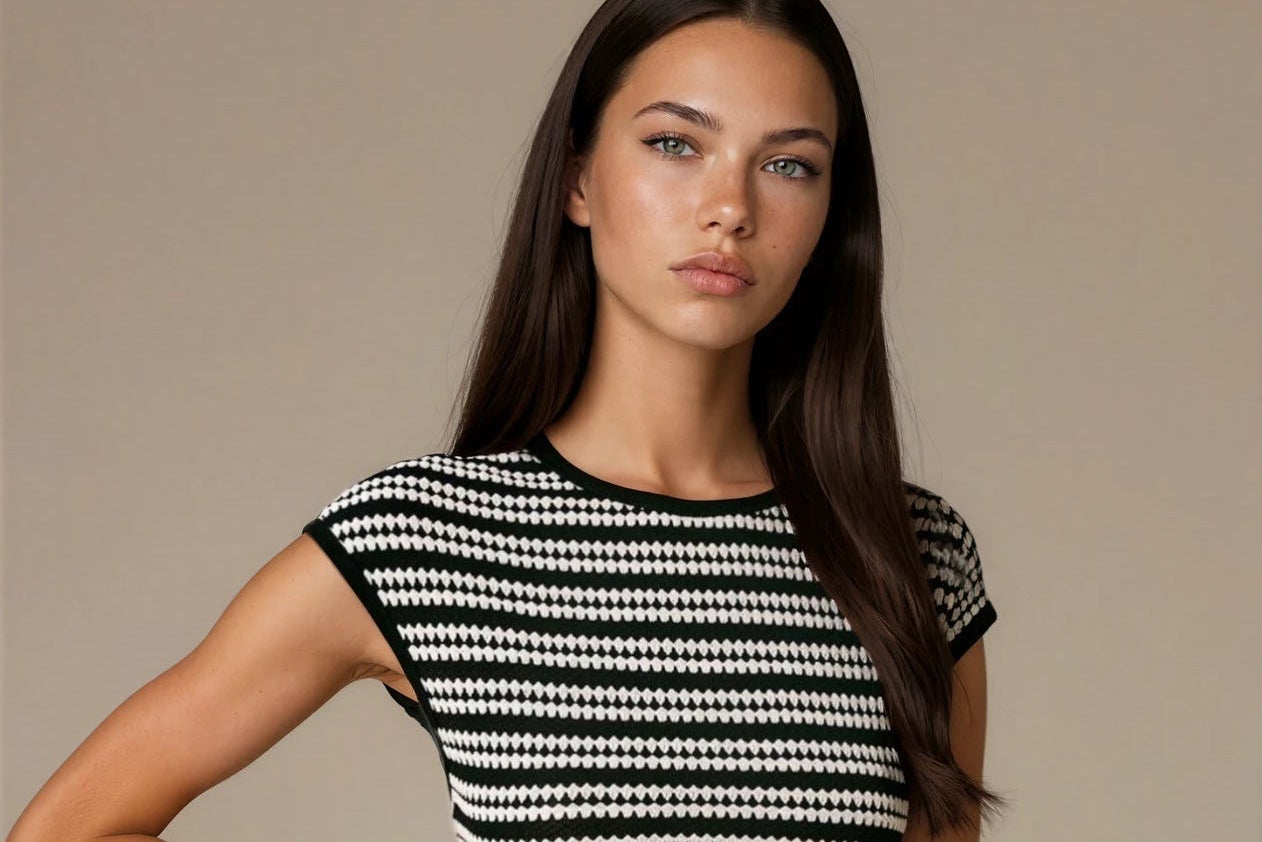 Woman wearing a black and white patterned dress against a beige background
