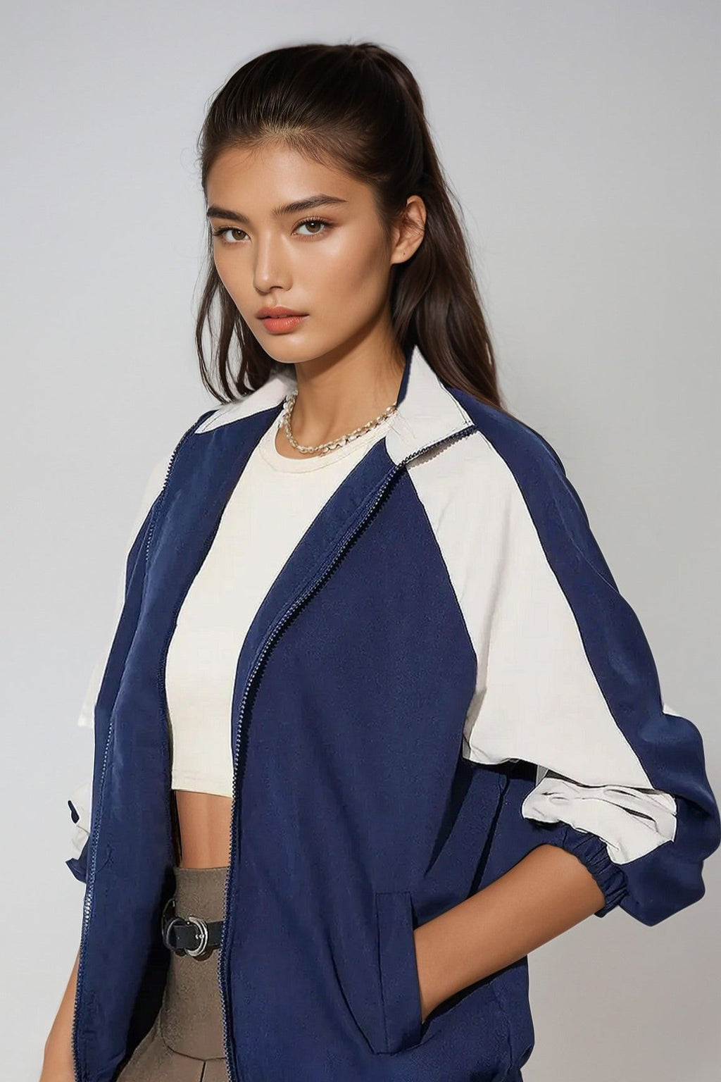 A woman wearing a blue and white zip up collared neck long sleeve jacket with no visible brand markings