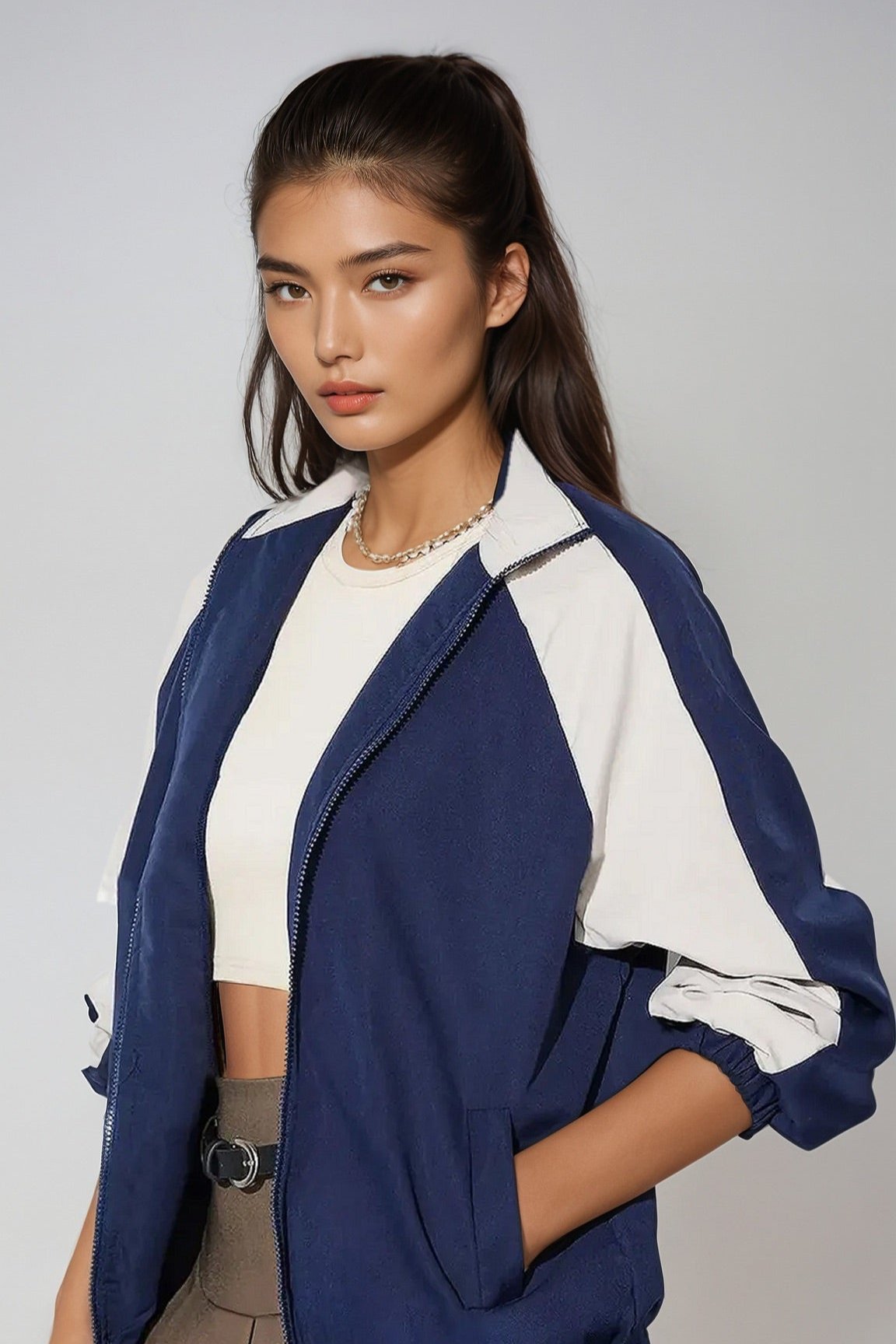 A woman wearing a blue and white zip up collared neck long sleeve jacket with no visible brand markings