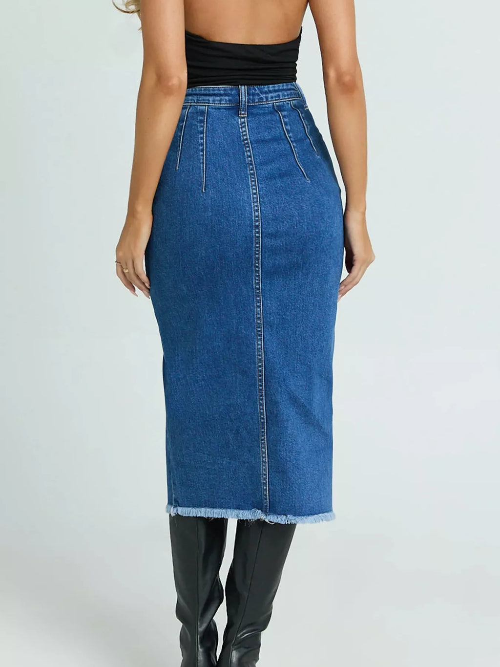 Blue denim skirt worn by a person on a white background