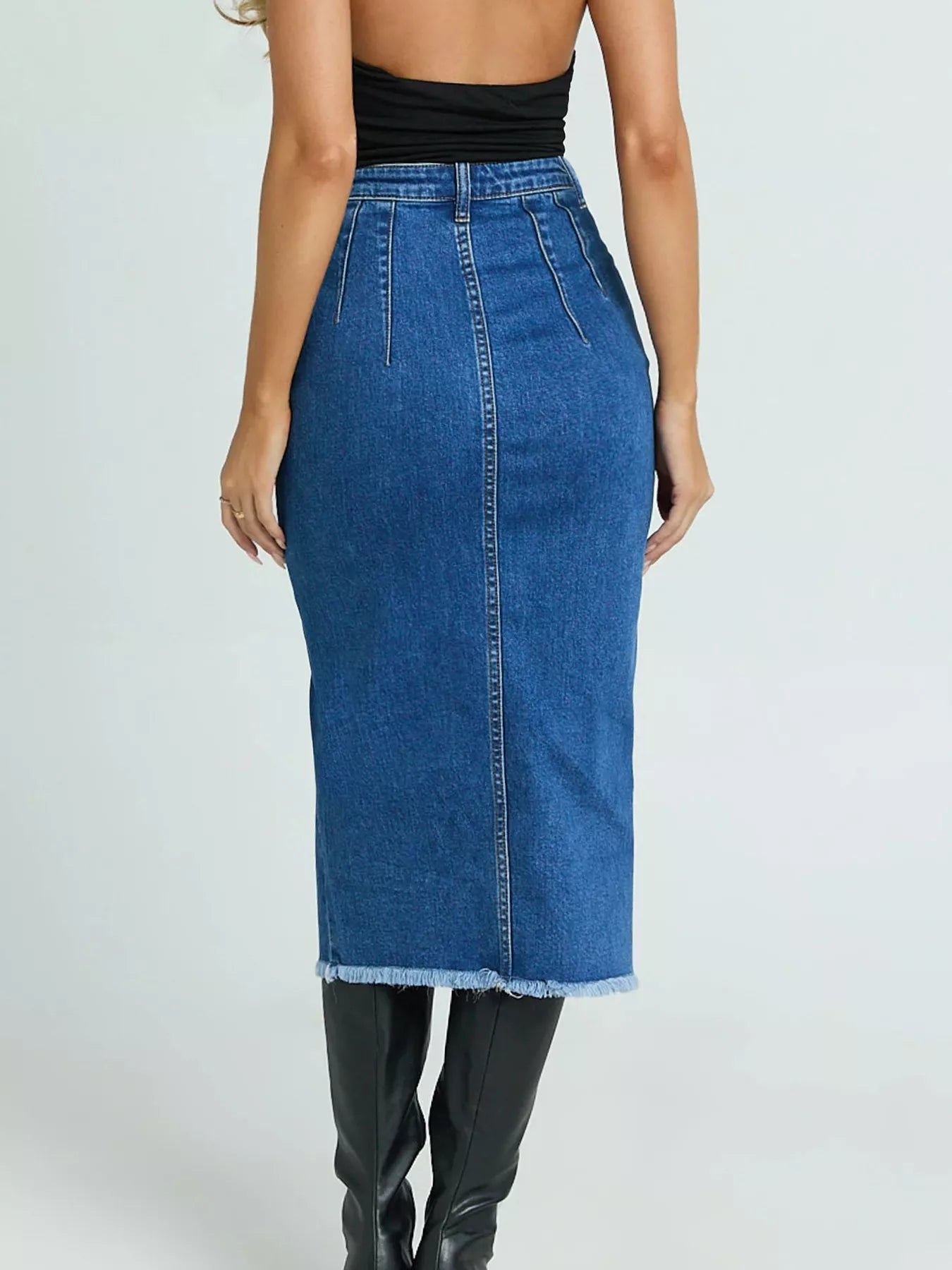 Blue denim skirt worn by a person on a white background