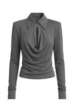 A dark gray long-sleeve top with a unique draped neckline and a small button detail at the collar, shown on a plain white background.
